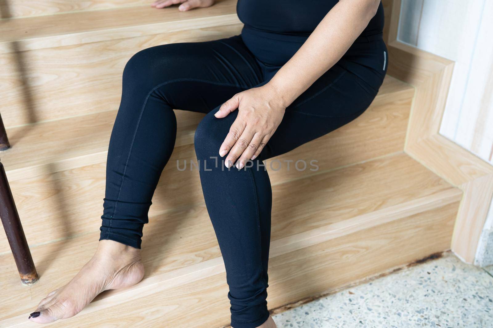 Asian middle-aged lady woman patient fall down the stairs because slippery surfaces and pain her knee.