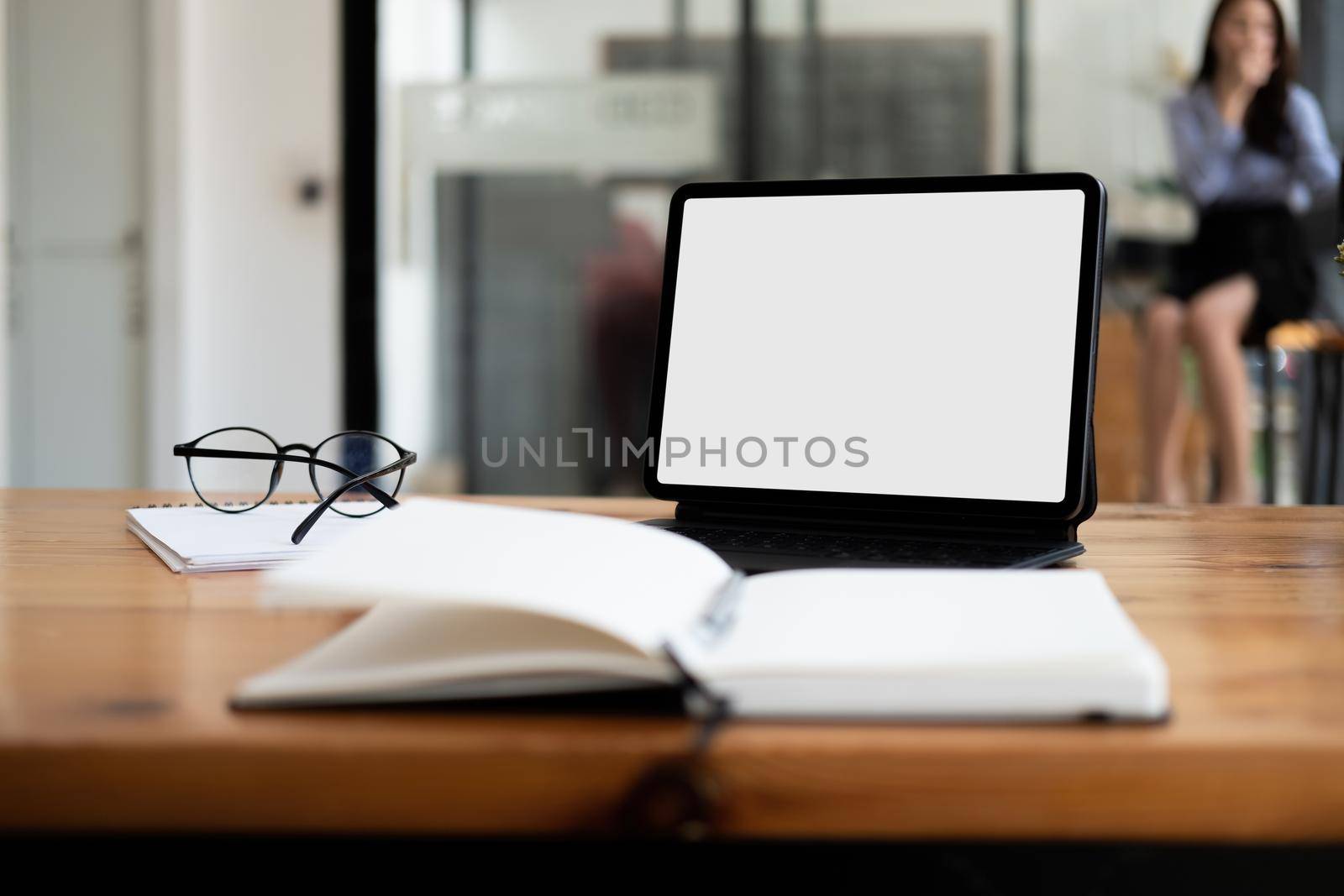 Shot of digital tablet with blank white screen, keyboard, cup of coffee on workspace desk.
