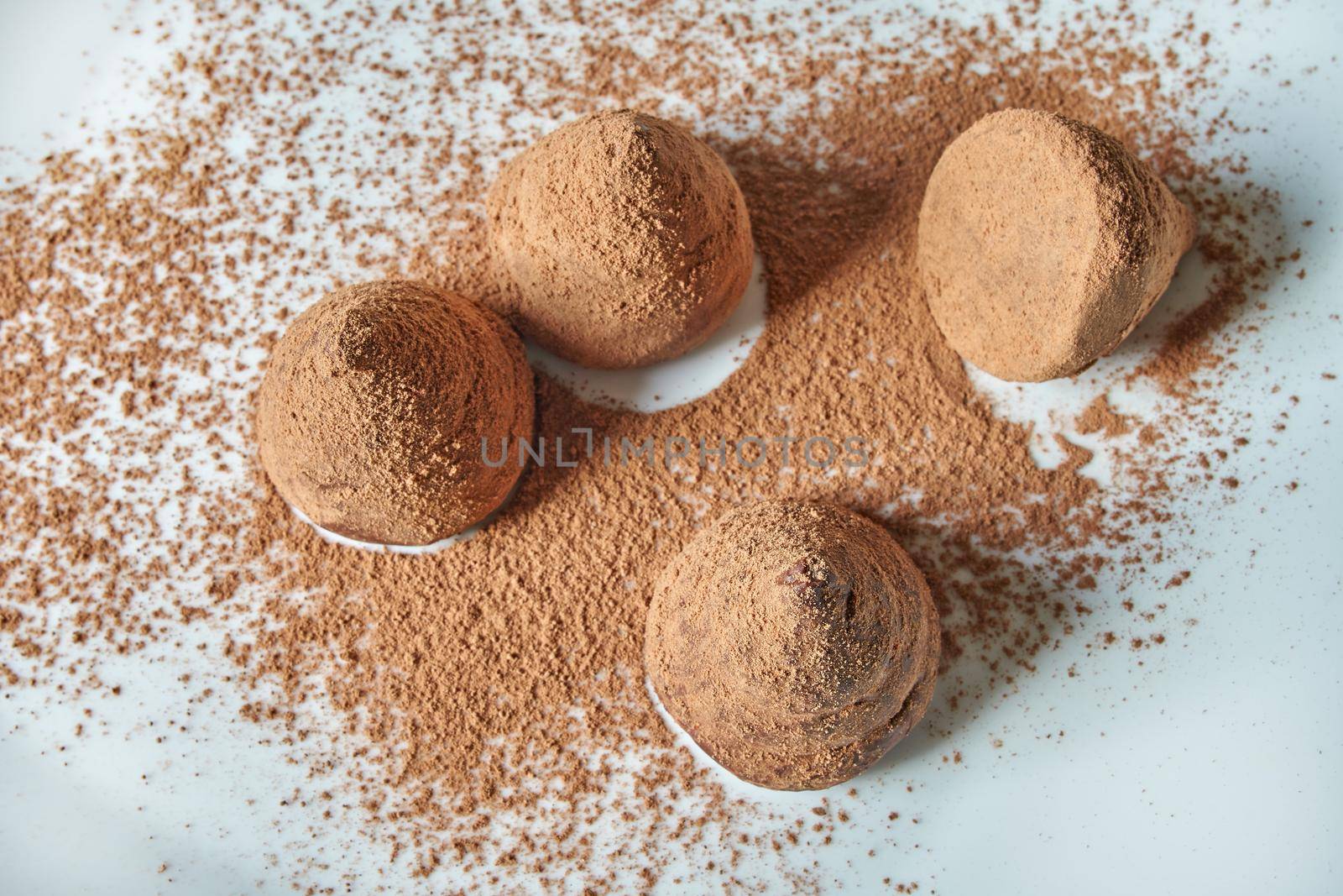 Chocolate truffles covered with cocoa on white background