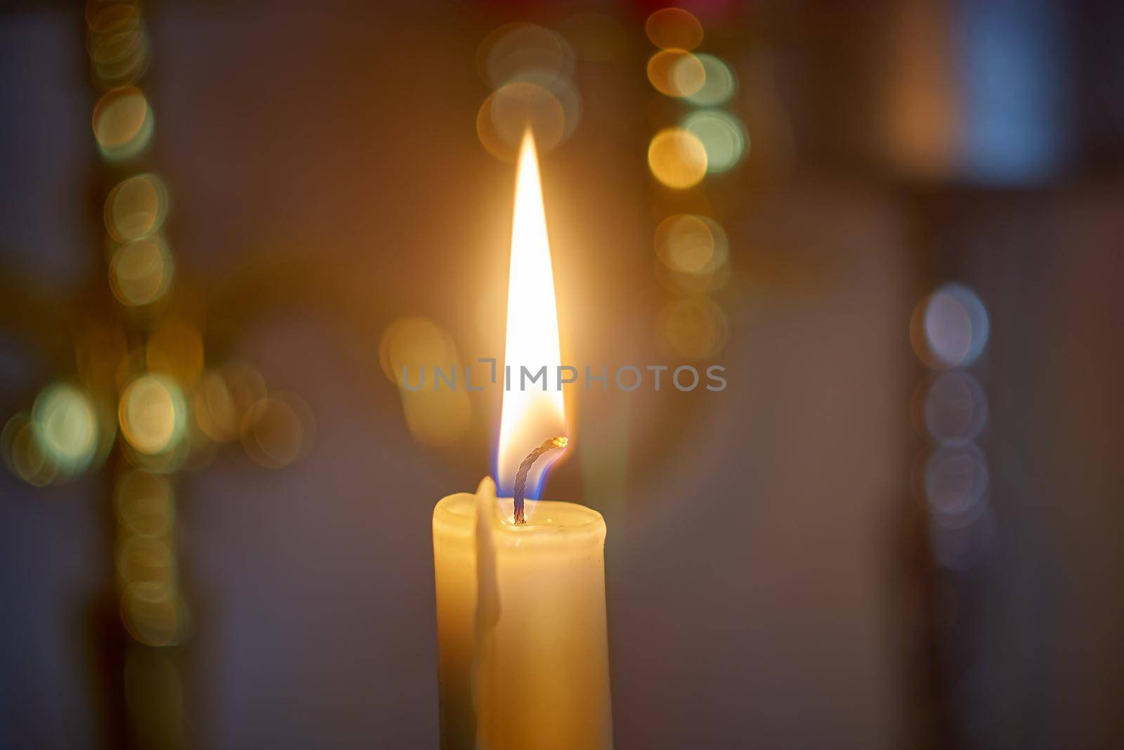 Candle flame light at night with bokeh on dark background.