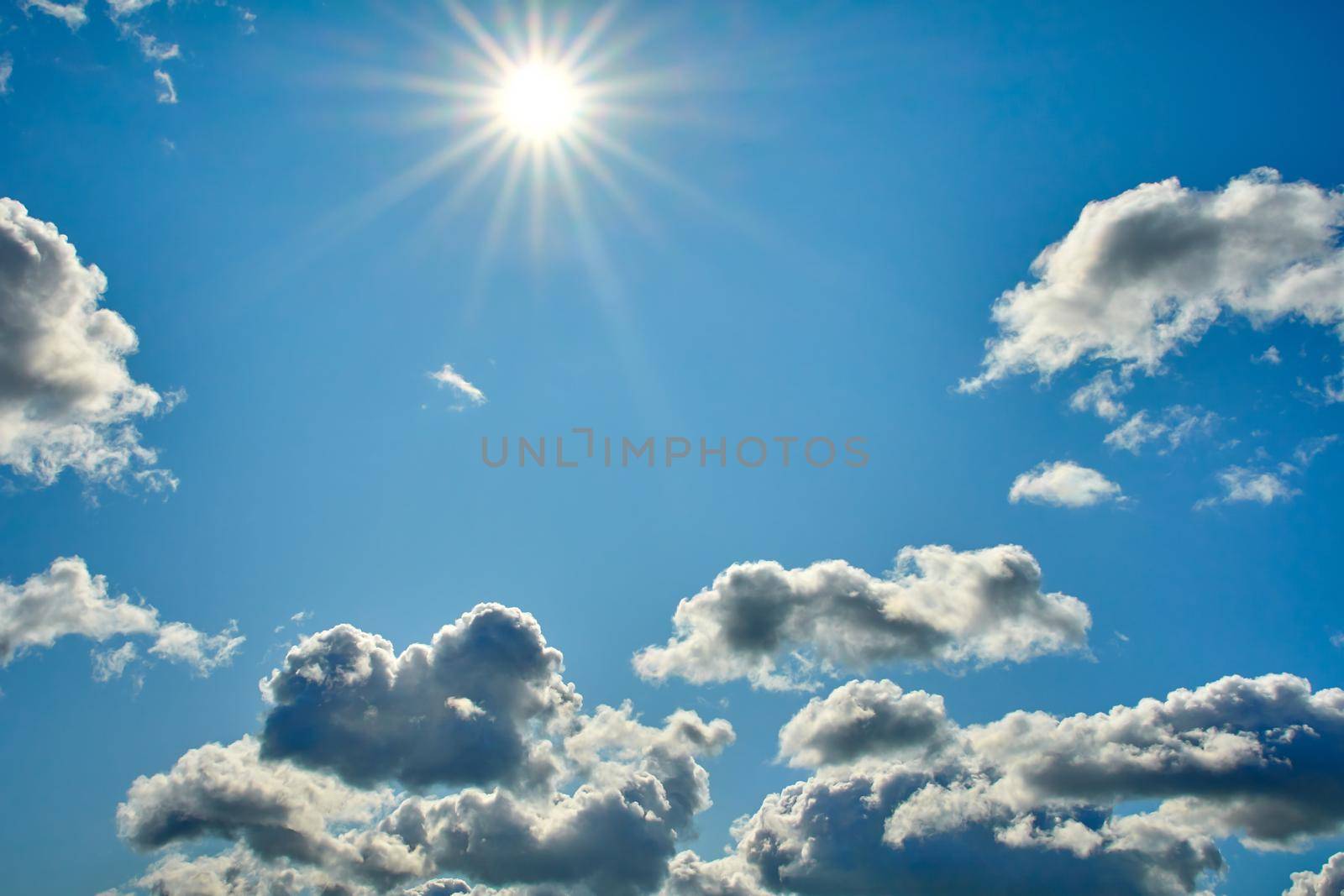 Blue sky with white clouds at high altitude with white condensation trails airliner