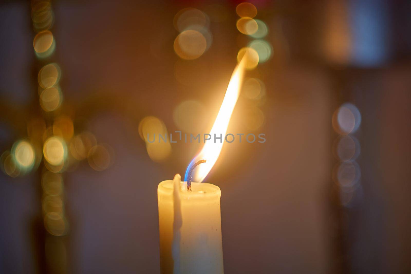 Candle flame light at night with bokeh on dark background.