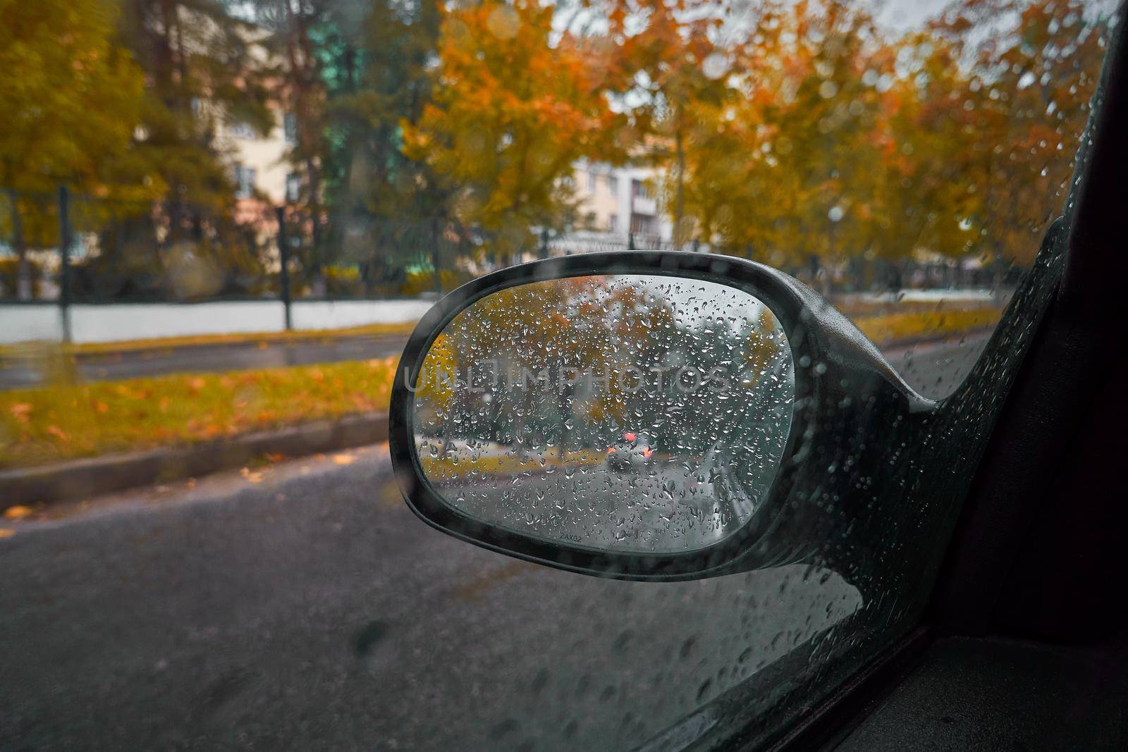 Raindrops on a car window, rural life in the rainy season abstract background, water drops on the glass, concept of driving a car
