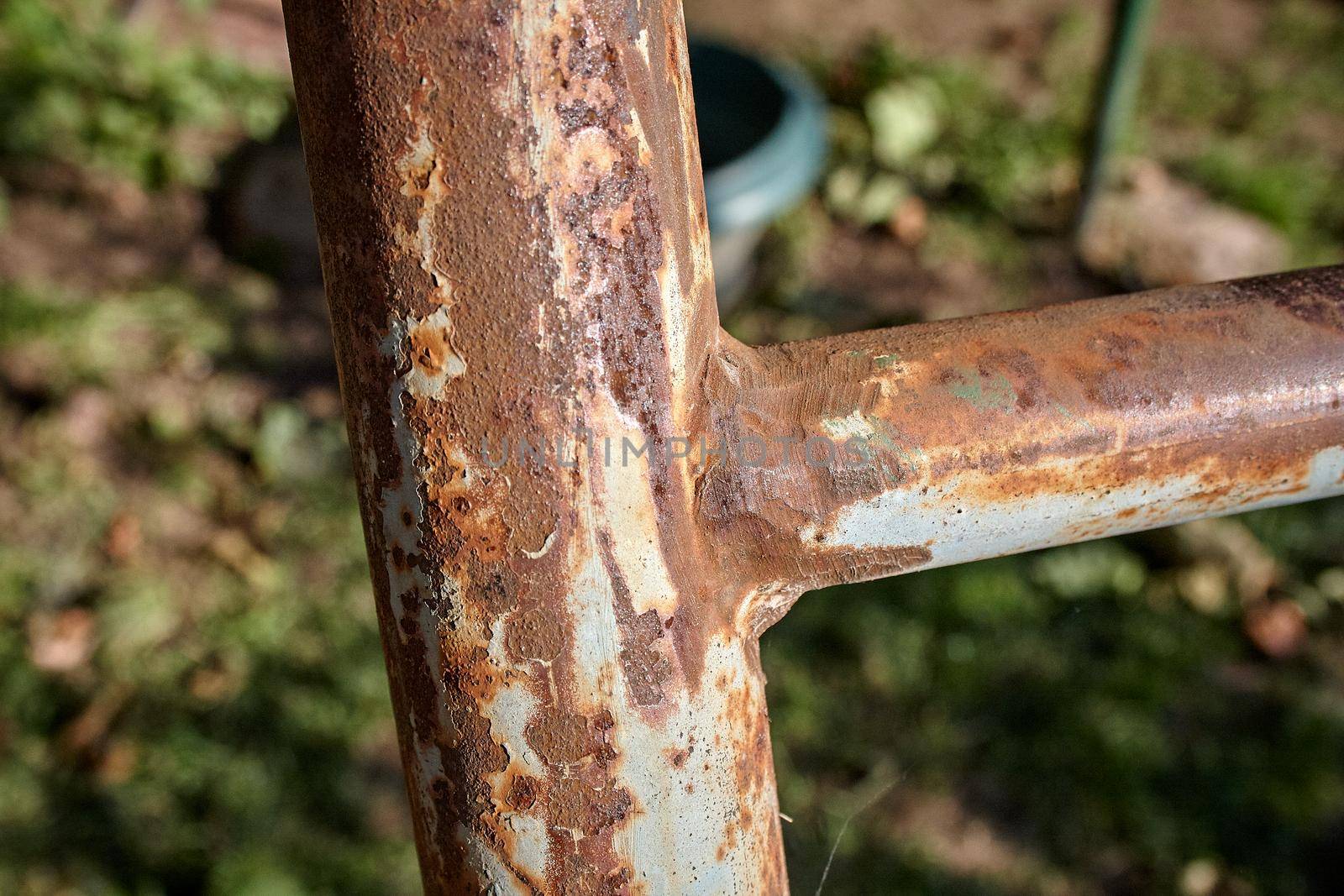 Rusty iron pole as part of a metal staircase. Close-up