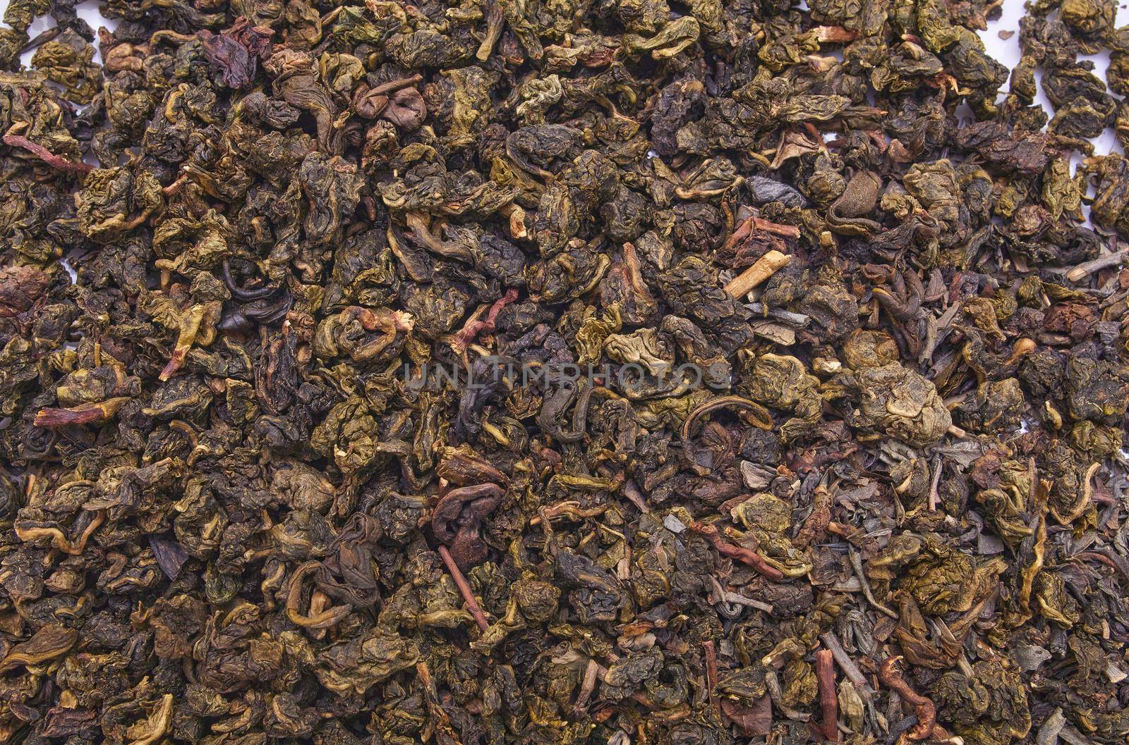 Milk oolong tea on a white background and close-up.Dry oolong tea leaves as a background. Fermented Chinese tea shot from above.