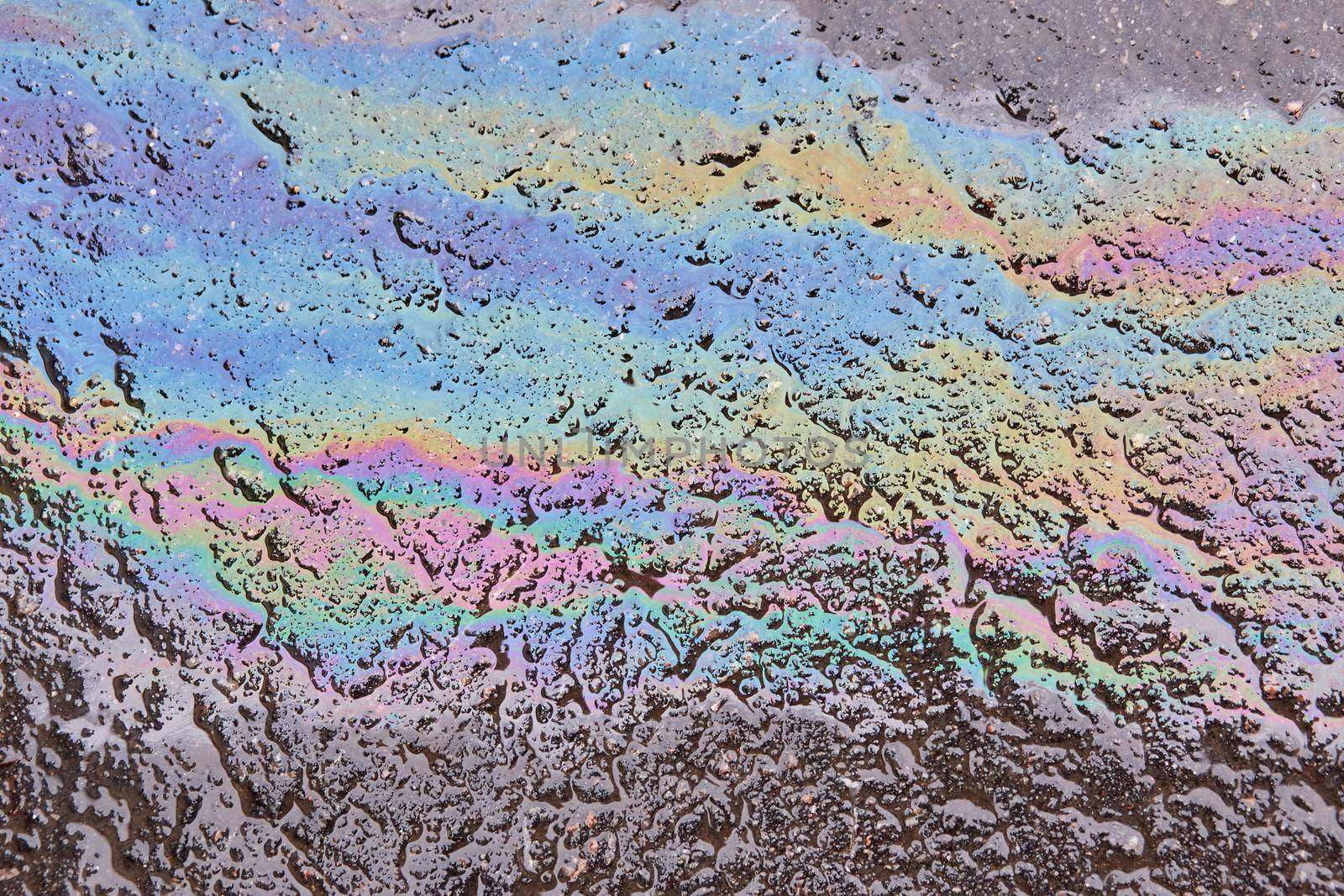 Oil spill on asphalt road background or texture