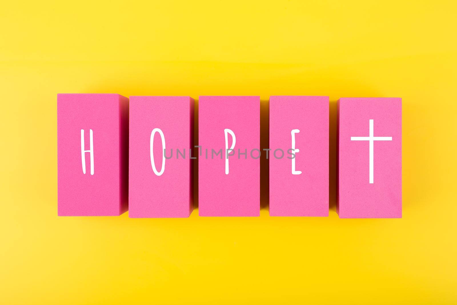 Modern religious minimal concept of hope with christian cross on bright yellow background. Biblical creative composition with single word hope and cross