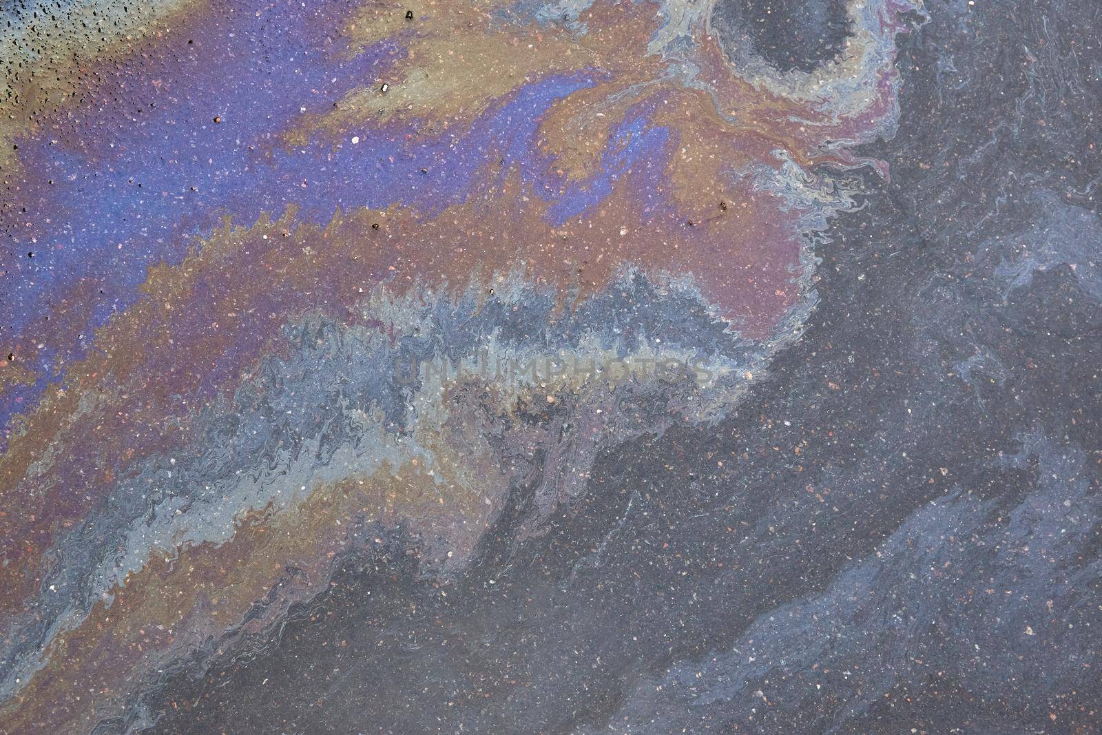 Oil stain on Asphalt, color Gasoline fuel spots on Asphalt Road as Texture or Background. Marbleized effect.