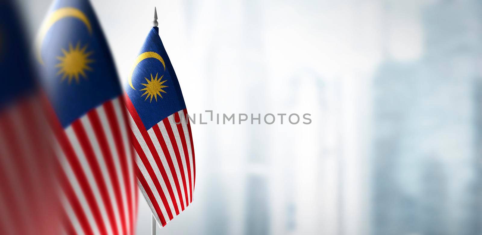 Small flags of Malaysia on a blurry background of the city.