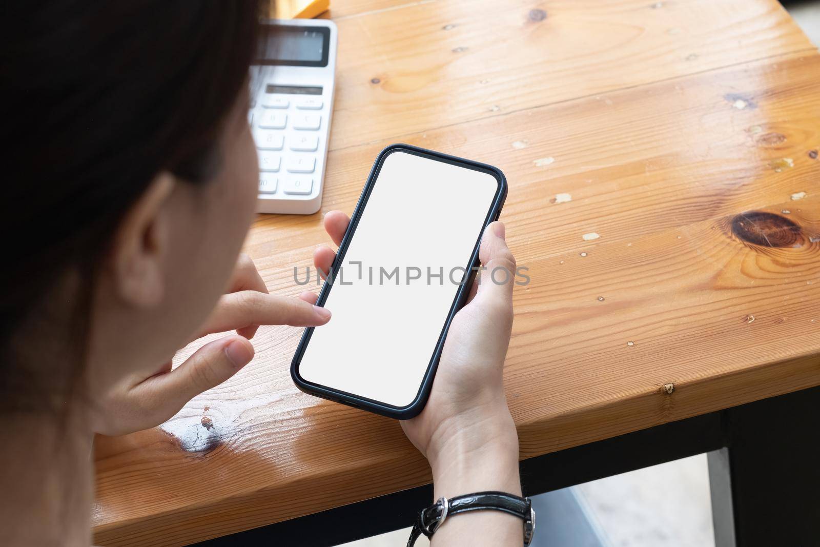 Young girl hands holding mobile phone touching finger mockup white blank display, empty screen for social media app ad at home. Mobile application tech concept,