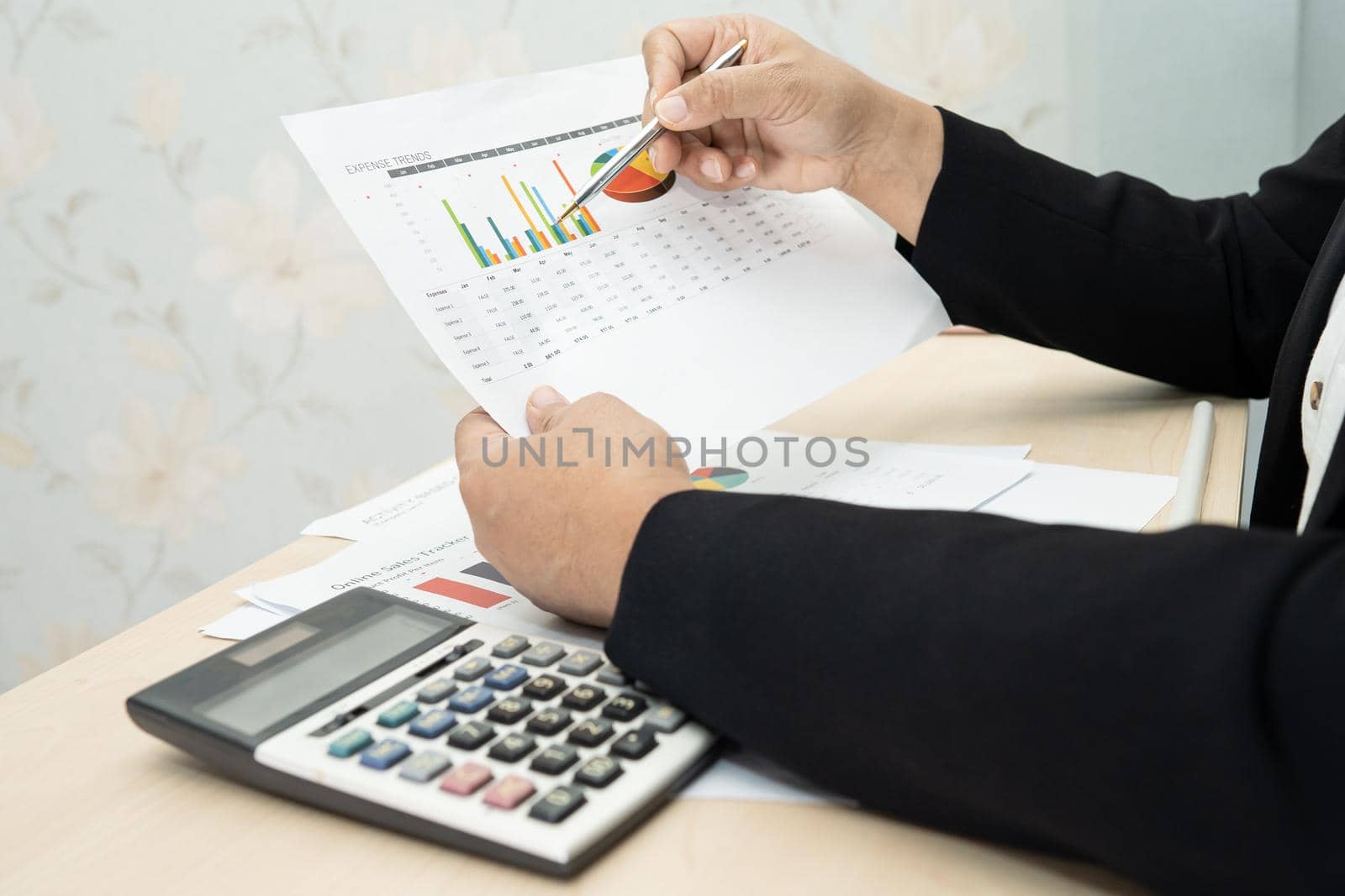 Asian accountant working and analyzing financial reports project accounting with chart graph and calculator in modern office, finance and business concept. by pamai