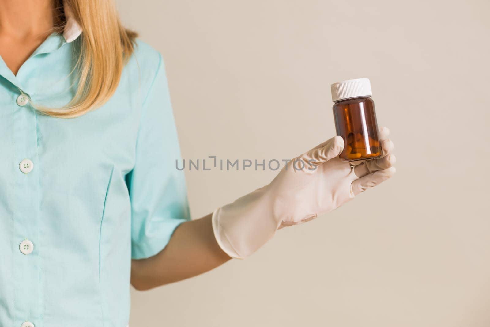 Image of medical nurse showing bottle of pills.