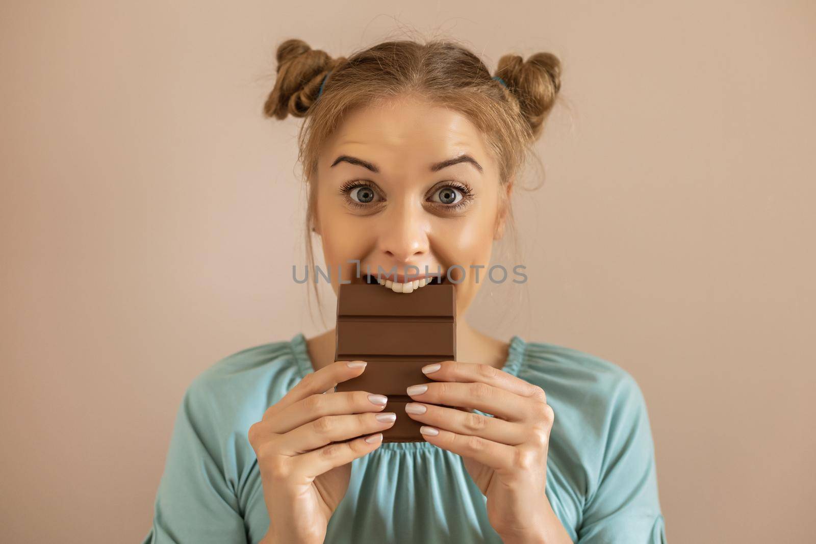 Portrait of happy cute woman enjoys eating chocolate.Toned image.