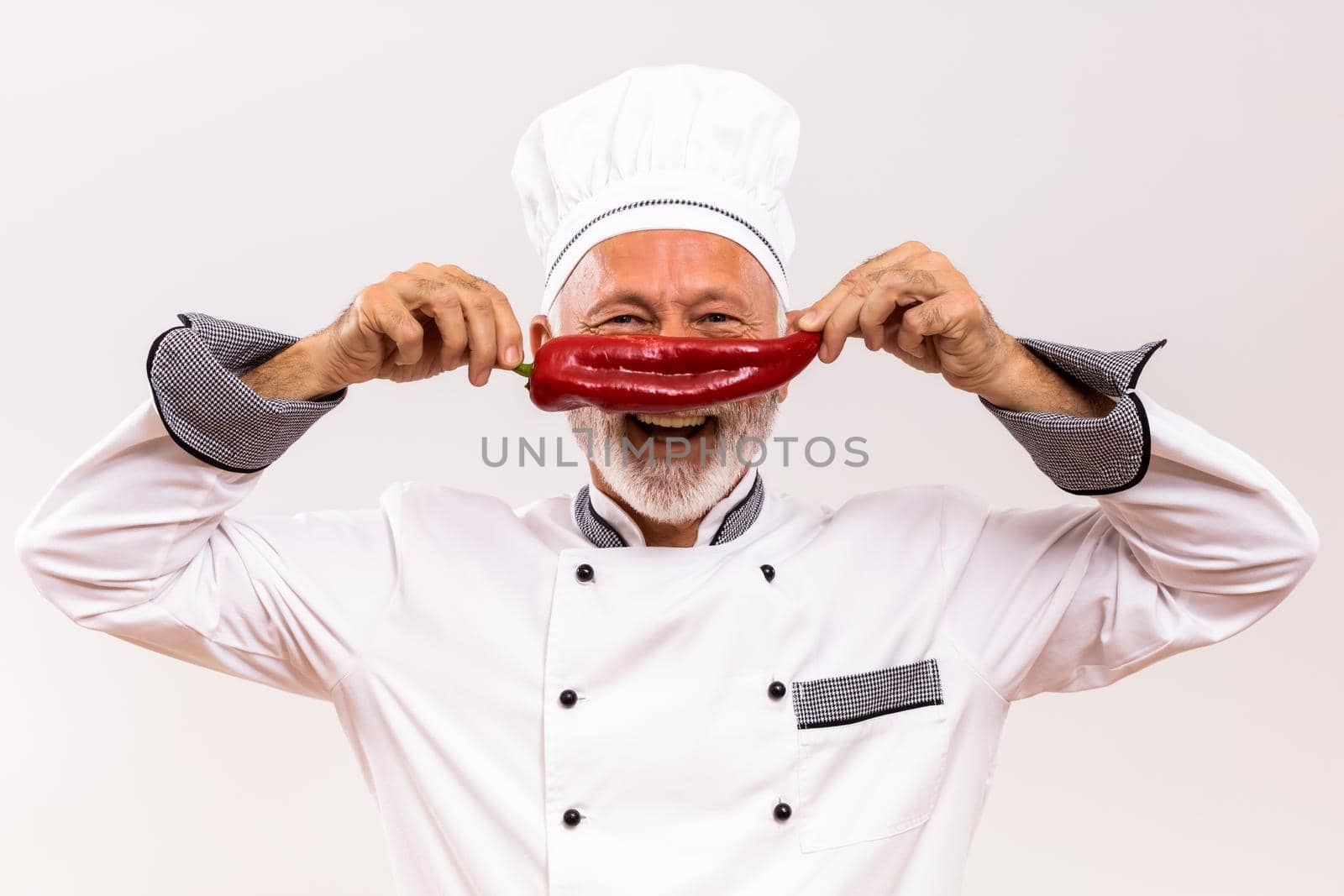 Portrait of happy senior chef having fun with vegetable.