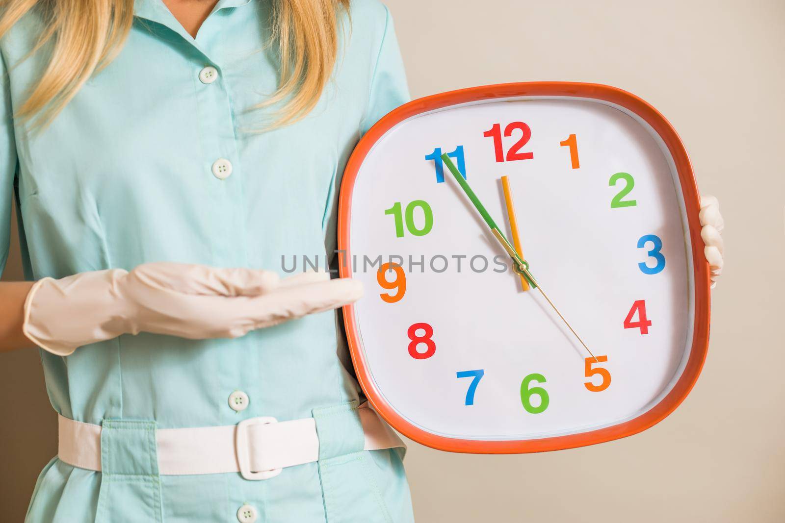 Image of medical nurse pointing at clock.