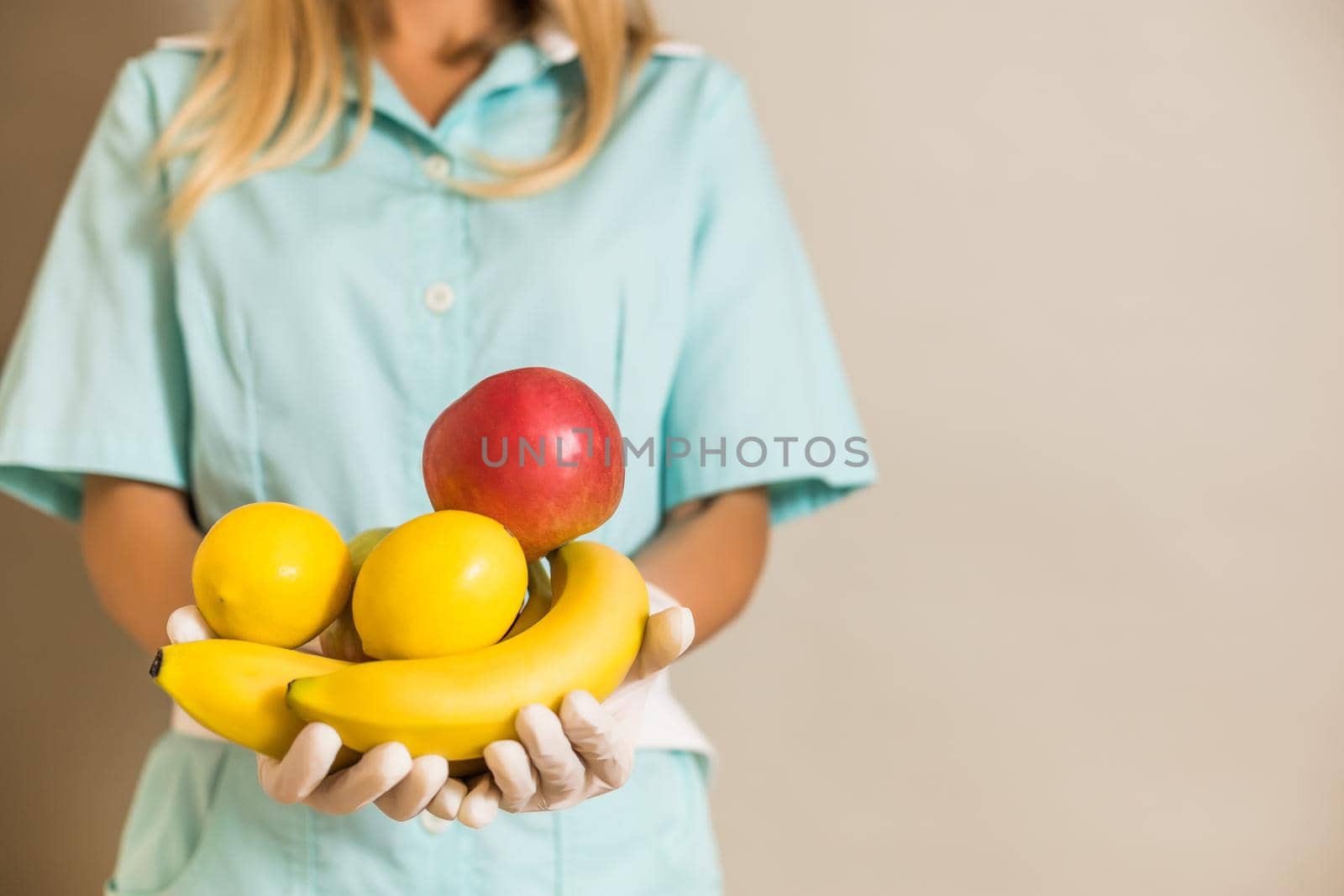 Image of medical nurse holding fruit.
