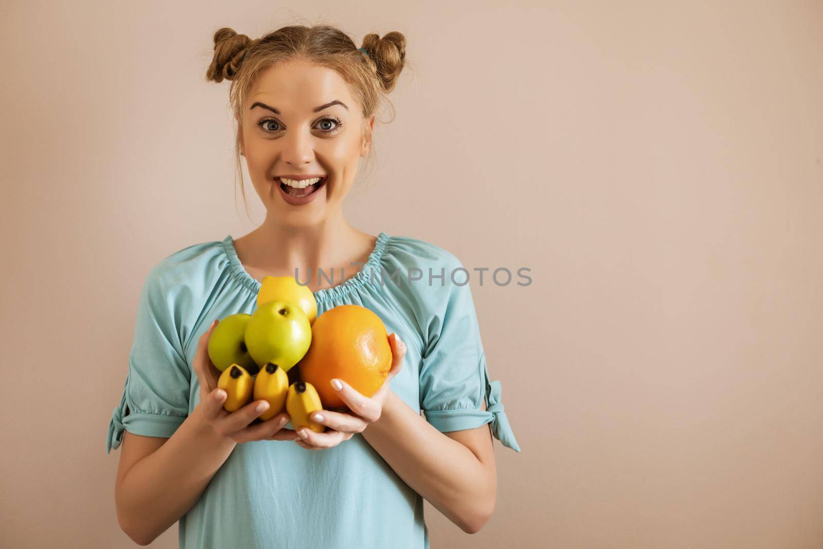 Portrait of cute happy woman holding bunch of fruit.Toned image.