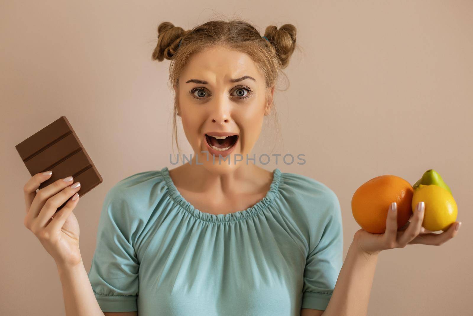 Cute woman is shouting because she is  tired of dieting and  eating fruit.Toned image.