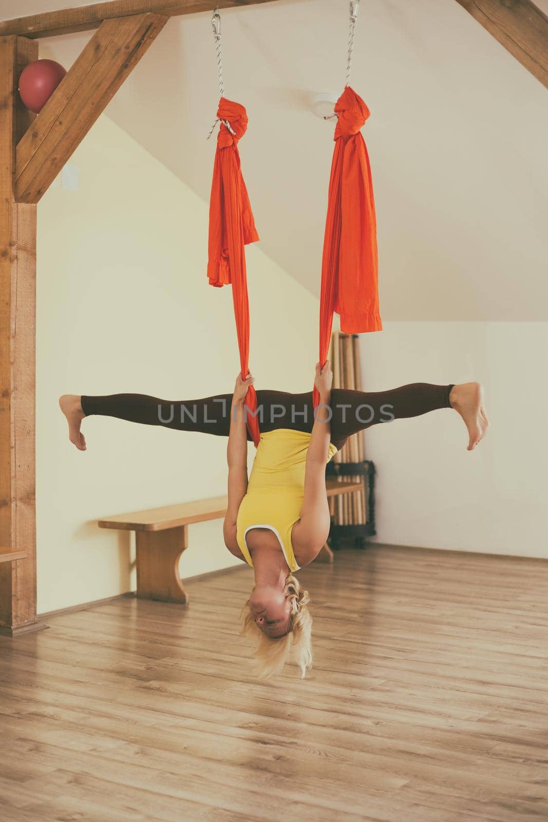 Woman doing aerial yoga in the fitness studio.Image is intentionally toned.