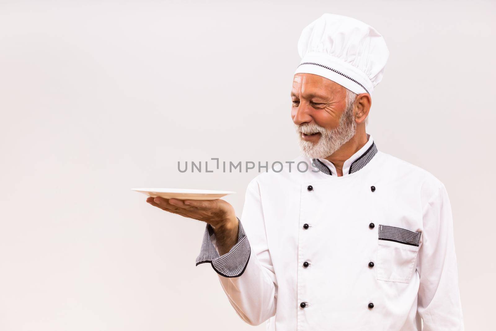 Senior chef with empty plate by Bazdar