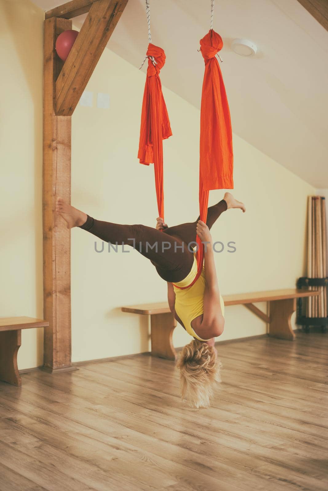 Woman doing aerial yoga in the fitness studio.Image is intentionally toned.