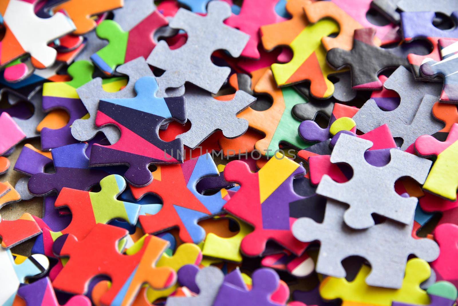 closeup heap of colorful jigsaw puzzle game in a box.