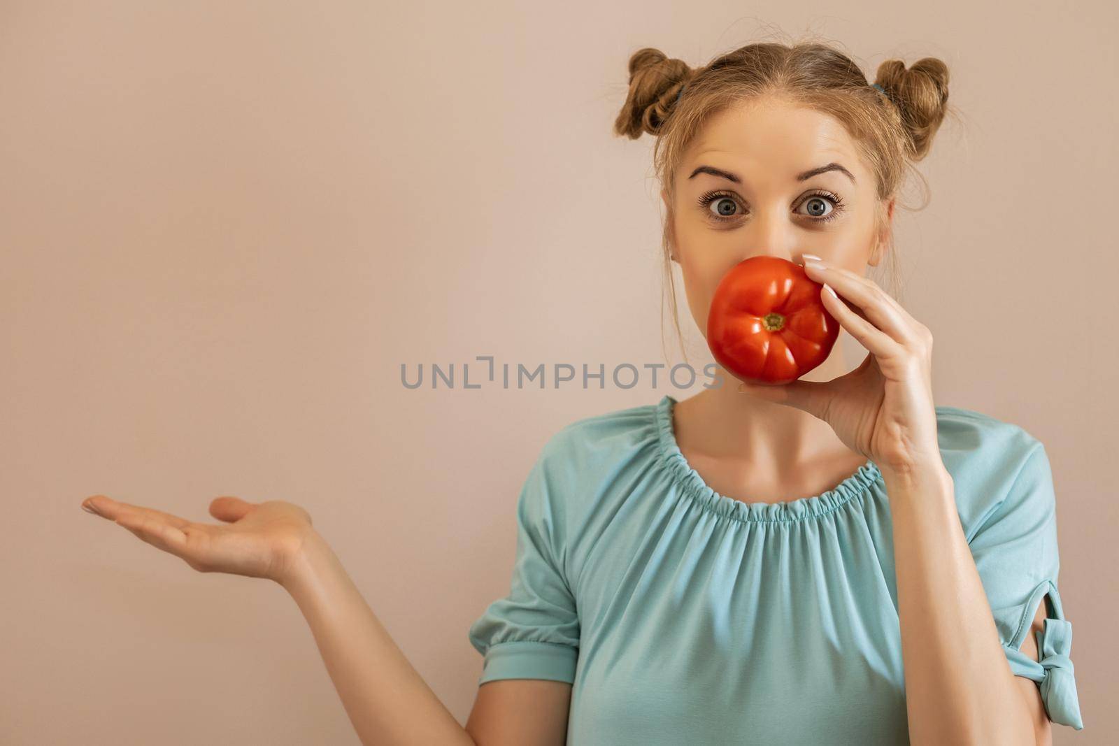Portrait of cute playful woman holding tomato and gesturing.Toned image.