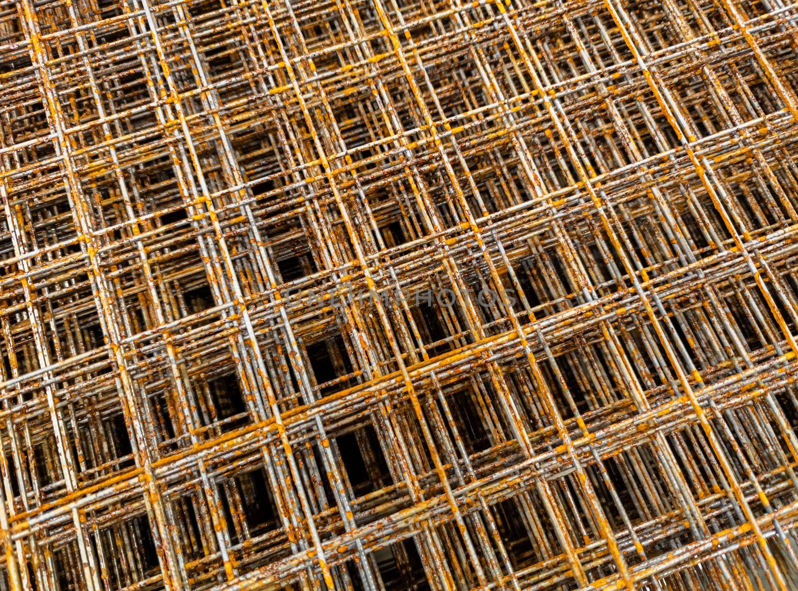 Thin rusty steel welded wire mesh for concrete reinforcing. Industrial material corrosion full frame background.