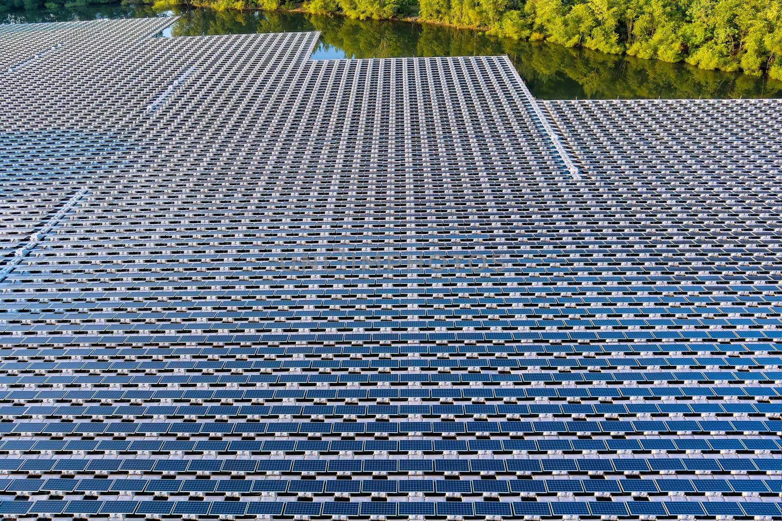 Aerial top view of renewable energy eco technology electric power industry. solar panels cells on floating in pond with water by ungvar