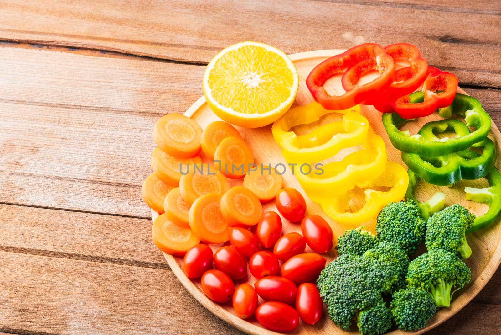 Top view of fresh organic fruits and vegetables in plate wood (carrot, Broccoli, tomato, orange, Bell pepper) on wooden table, Healthy lifestyle diet food concept