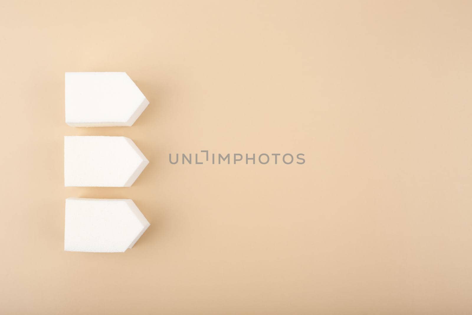 Flat lay with three white make up sponges on pastel beige background with copy space by Senorina_Irina
