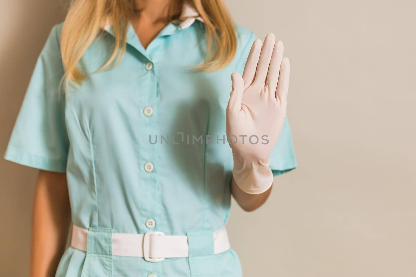 Image of medical nurse showing stop sign.