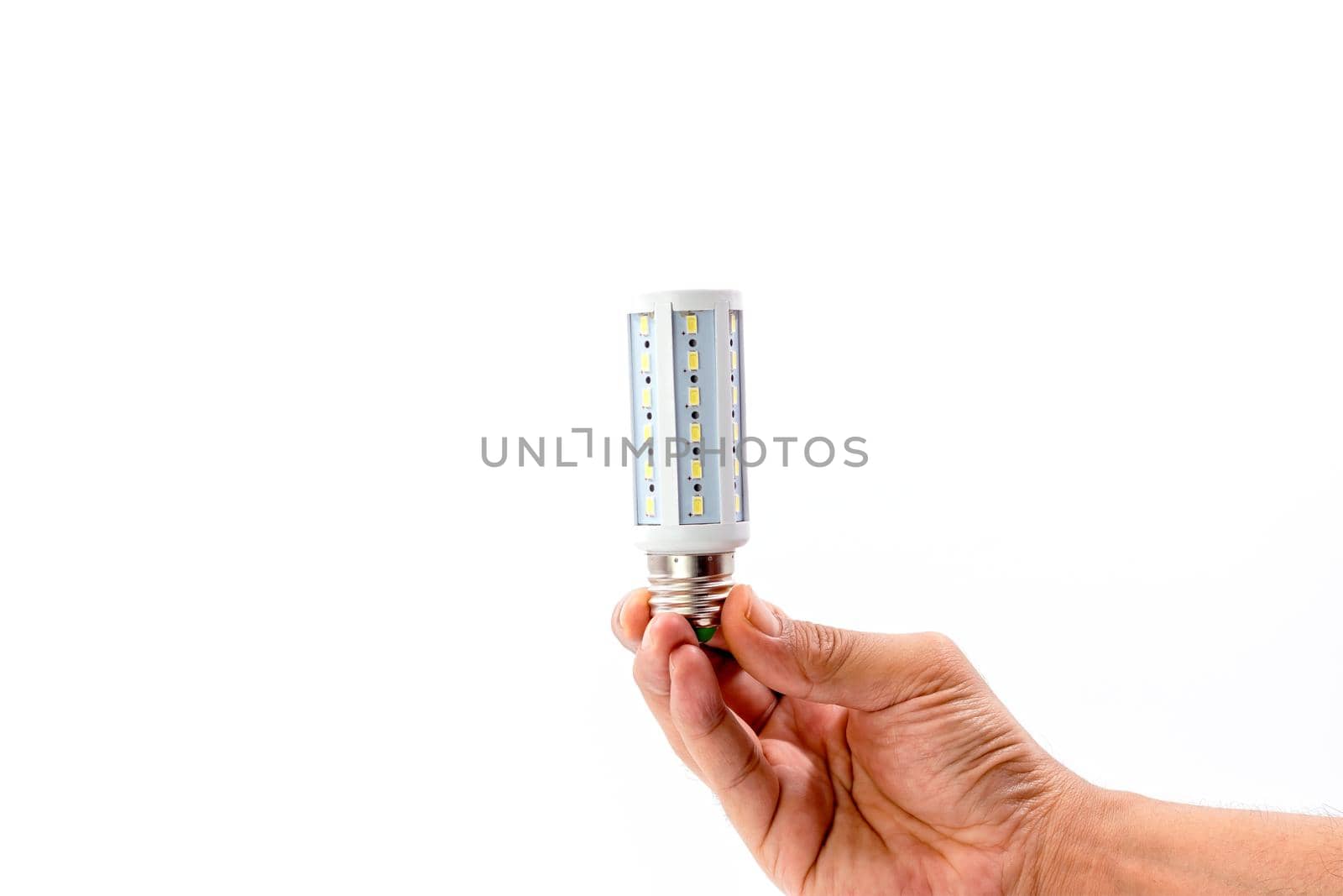 Human hand holding LED light bulb isolated on white background.