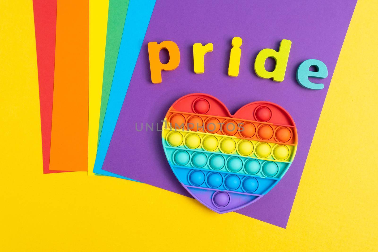 Text Pride Month LGBTQ with rainbow wooden letters. Pop it toy by darksoul72