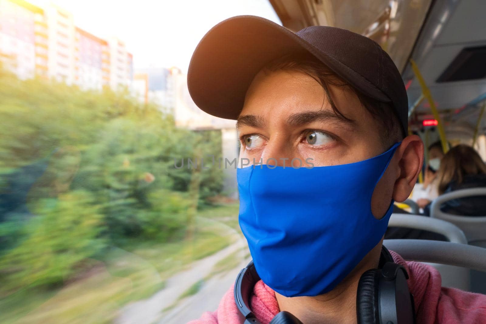 Portrait of a young man in a mask on a bus. Travel by public transport by bus