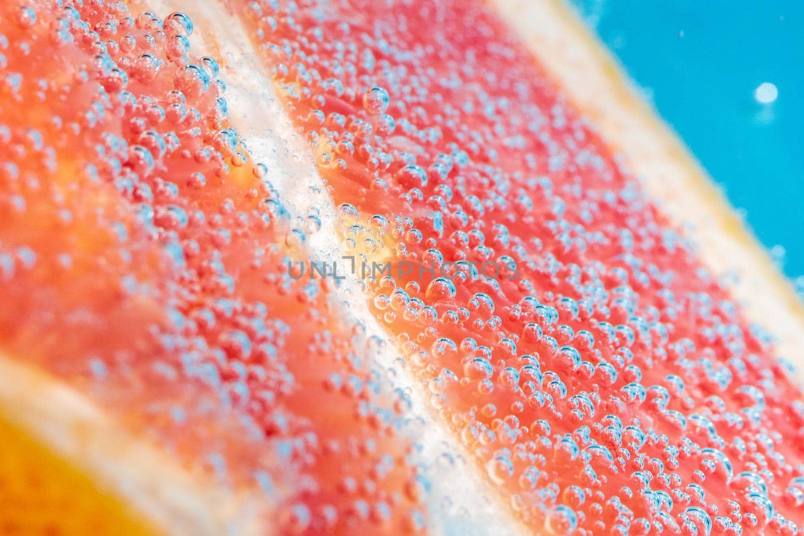 Grapefruit close up in soda water with bubbles. Summer drink concept.