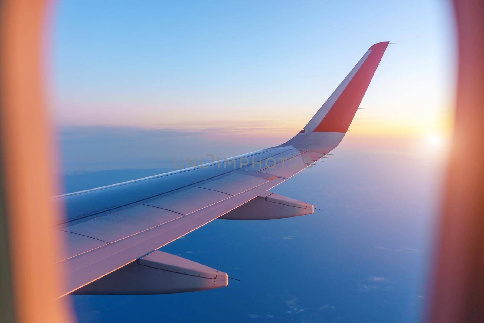 Sunrise with an airplane wing. For tourist operators. The concept of travel