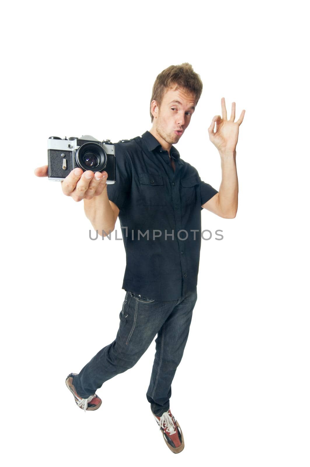 Young man standing with film camera isolated on white background