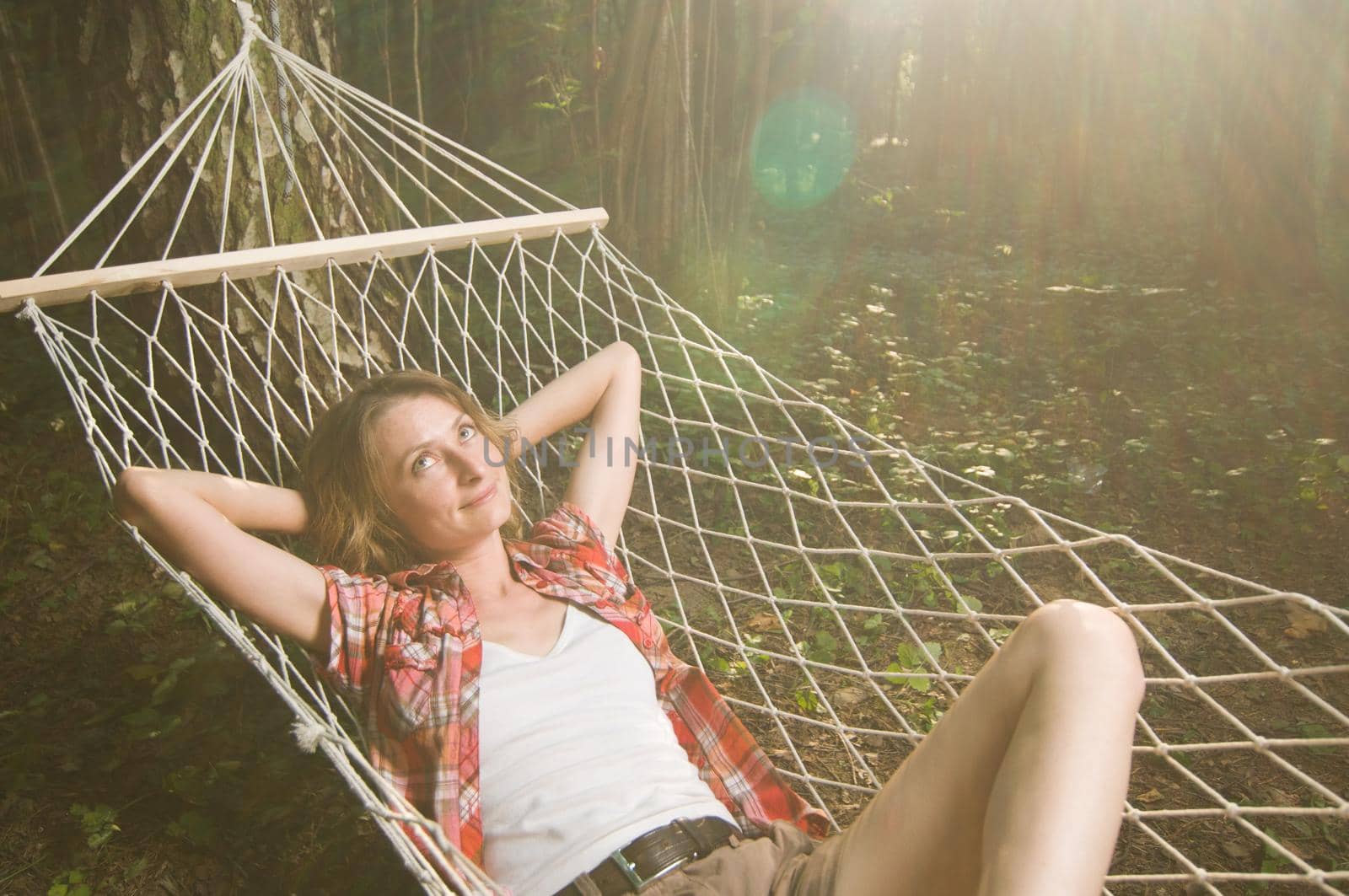 Beautiful woman relaxing in hammock out in the woods