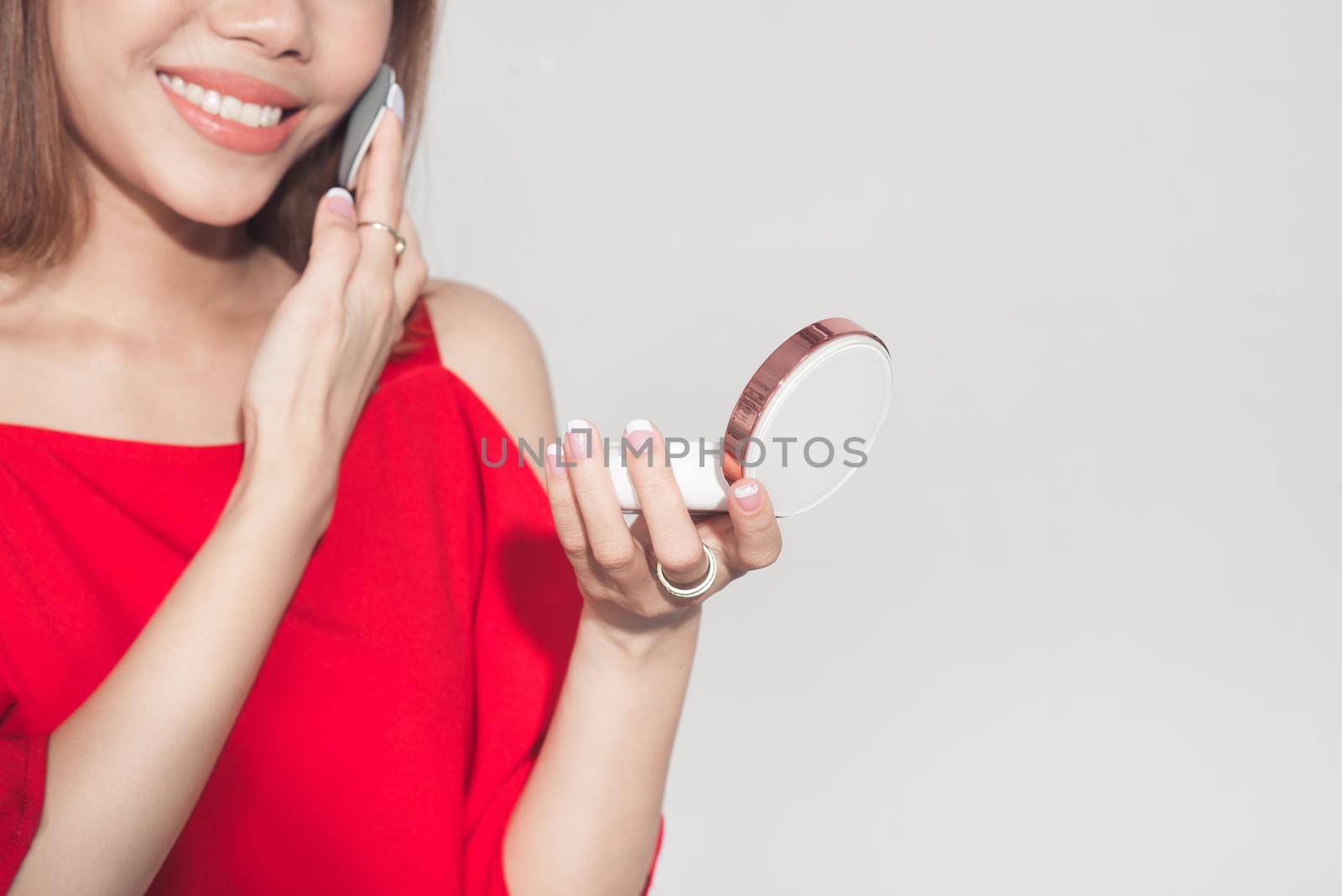 Fashion lifestyle portrait of young asian woman holding foundation cosmetic product 