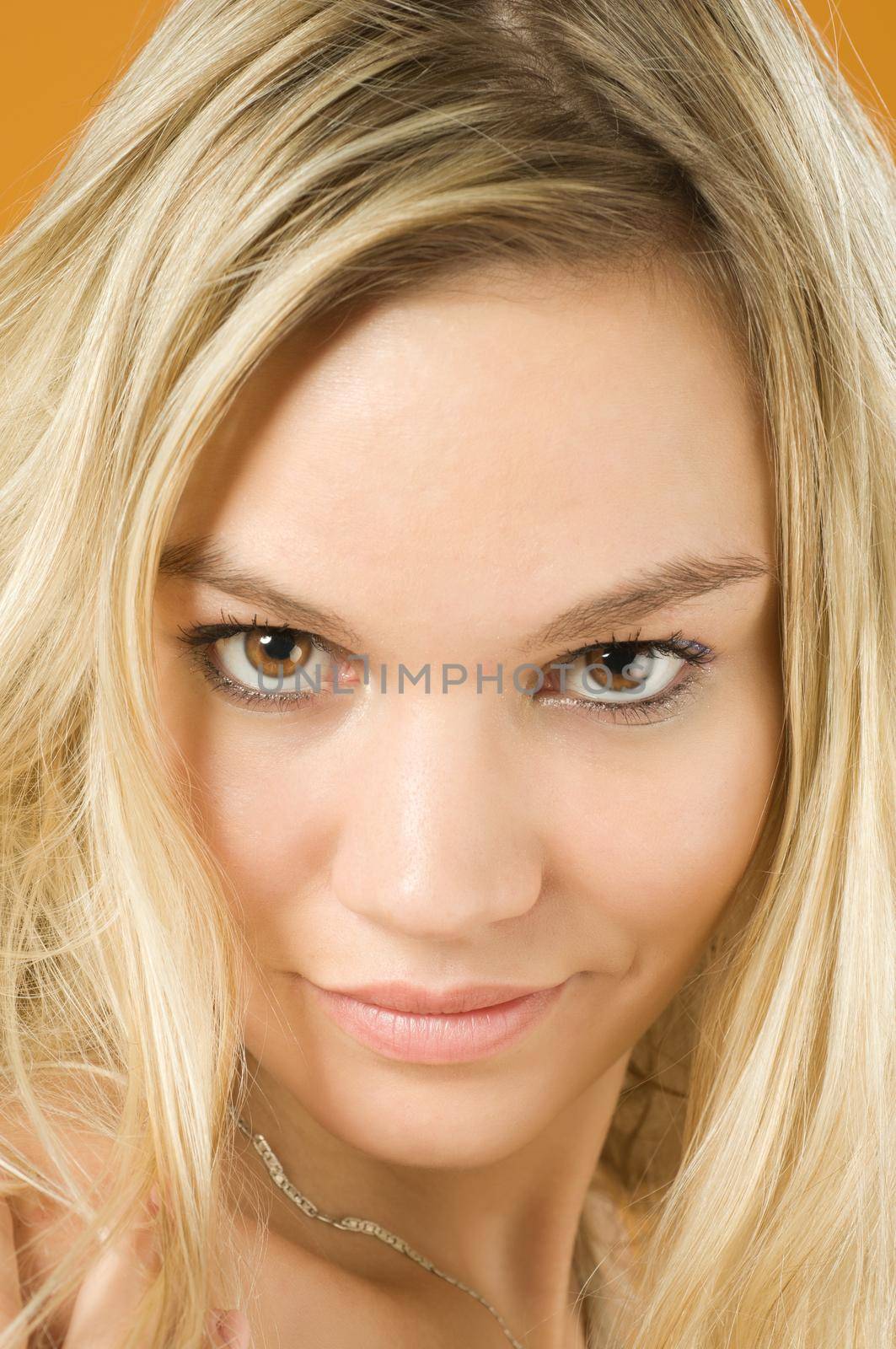 Portrait on sensual blond girl over yellow background
