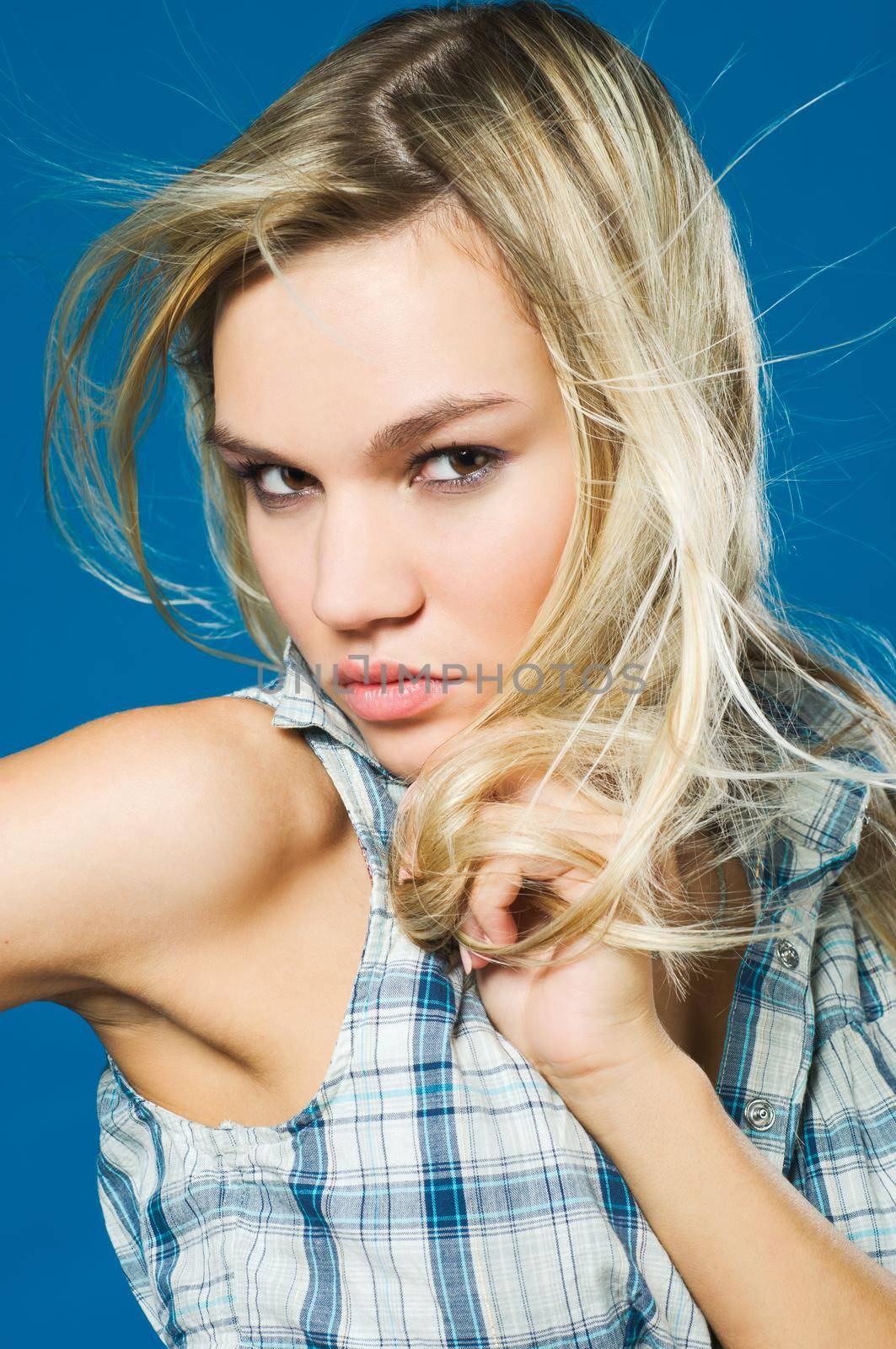 Portrait on sensual blond girl over blue background