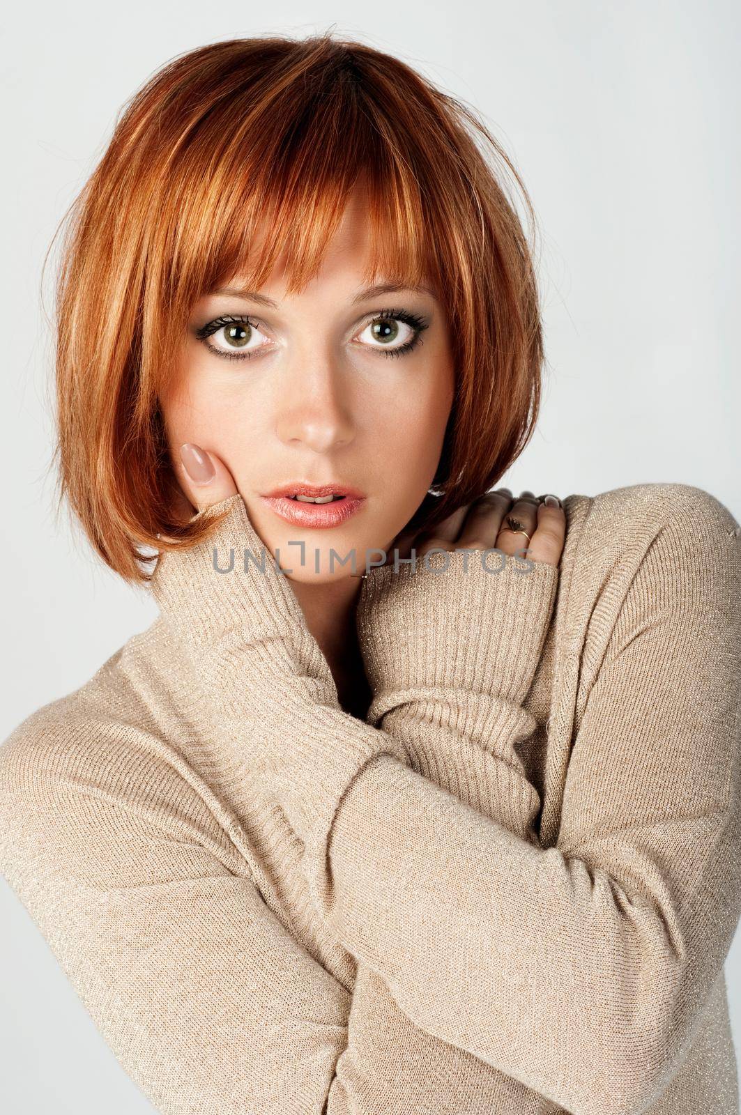 Portrait of red haired girl with hands touching face