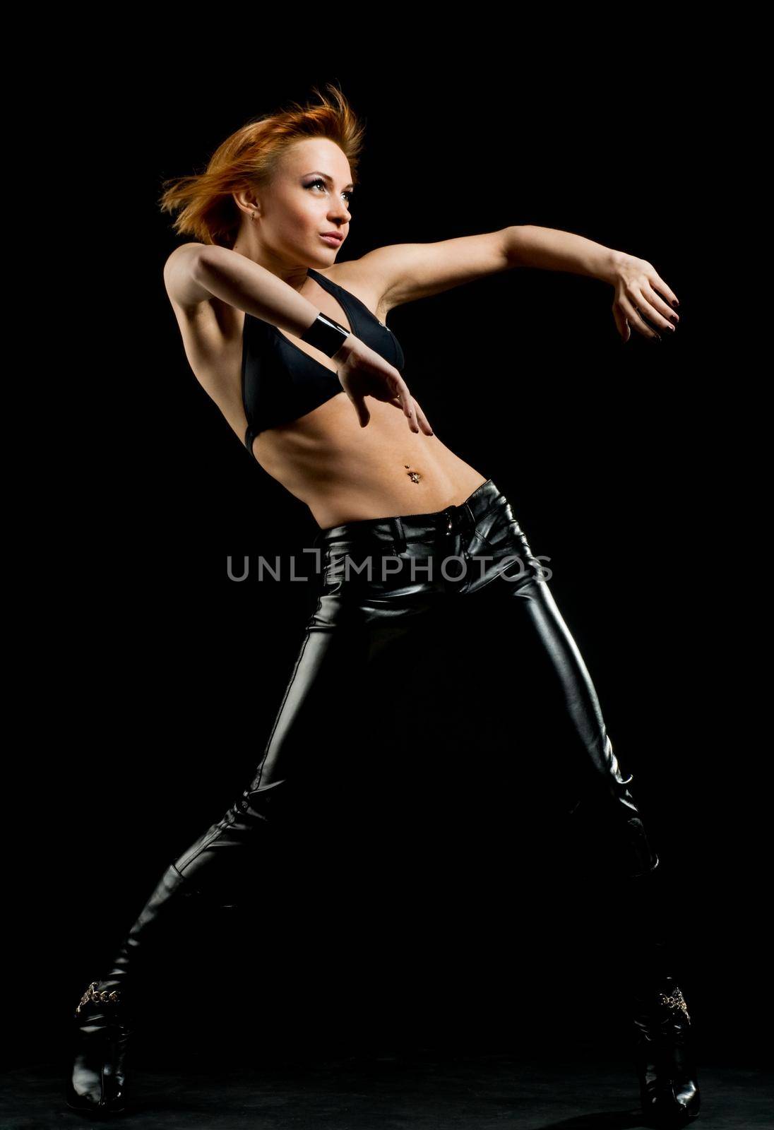 Studio shot of beautiful red dancer on black background
