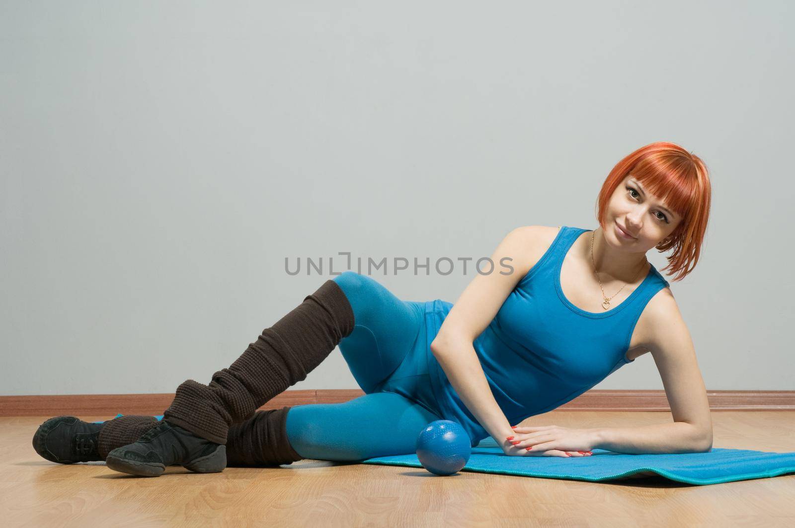 Red-haired fitness girl with yoga mat by nikitabuida