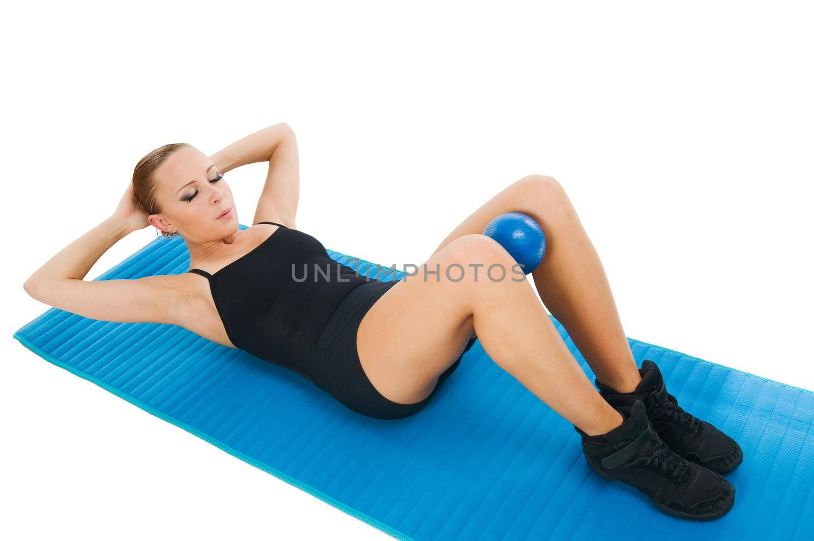 Beautiful fit red girl practicing pilates or callanetics with ball and blue yoga mat