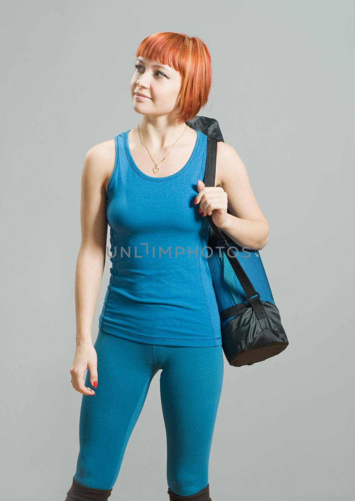 Red-haired fitness girl with yoga mat by nikitabuida