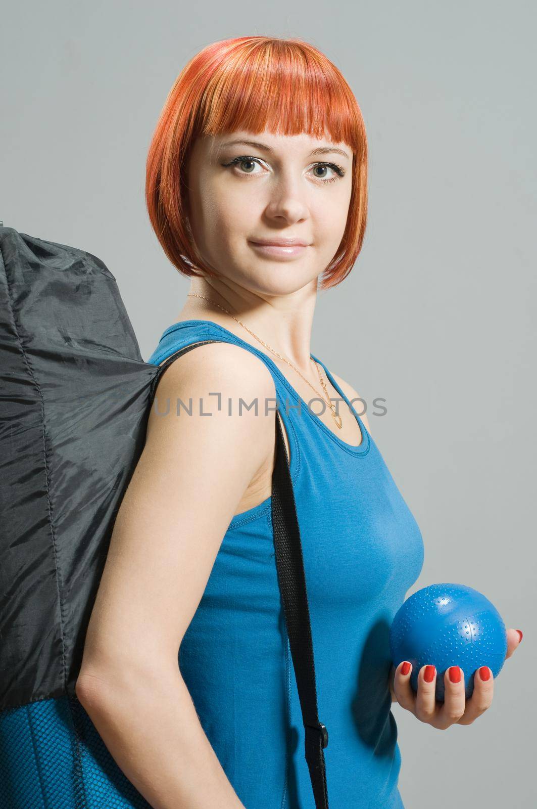 Red-haired fitness girl with yoga mat by nikitabuida