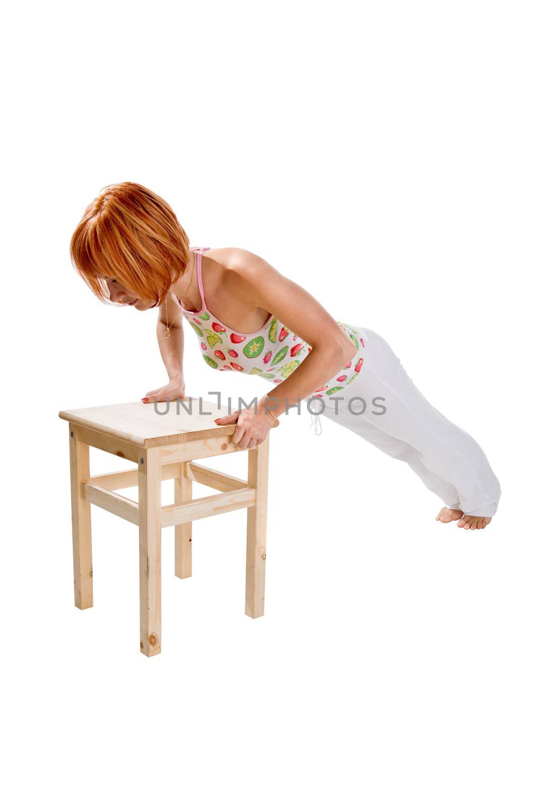 Red haired girl performing fitness exercises on white background