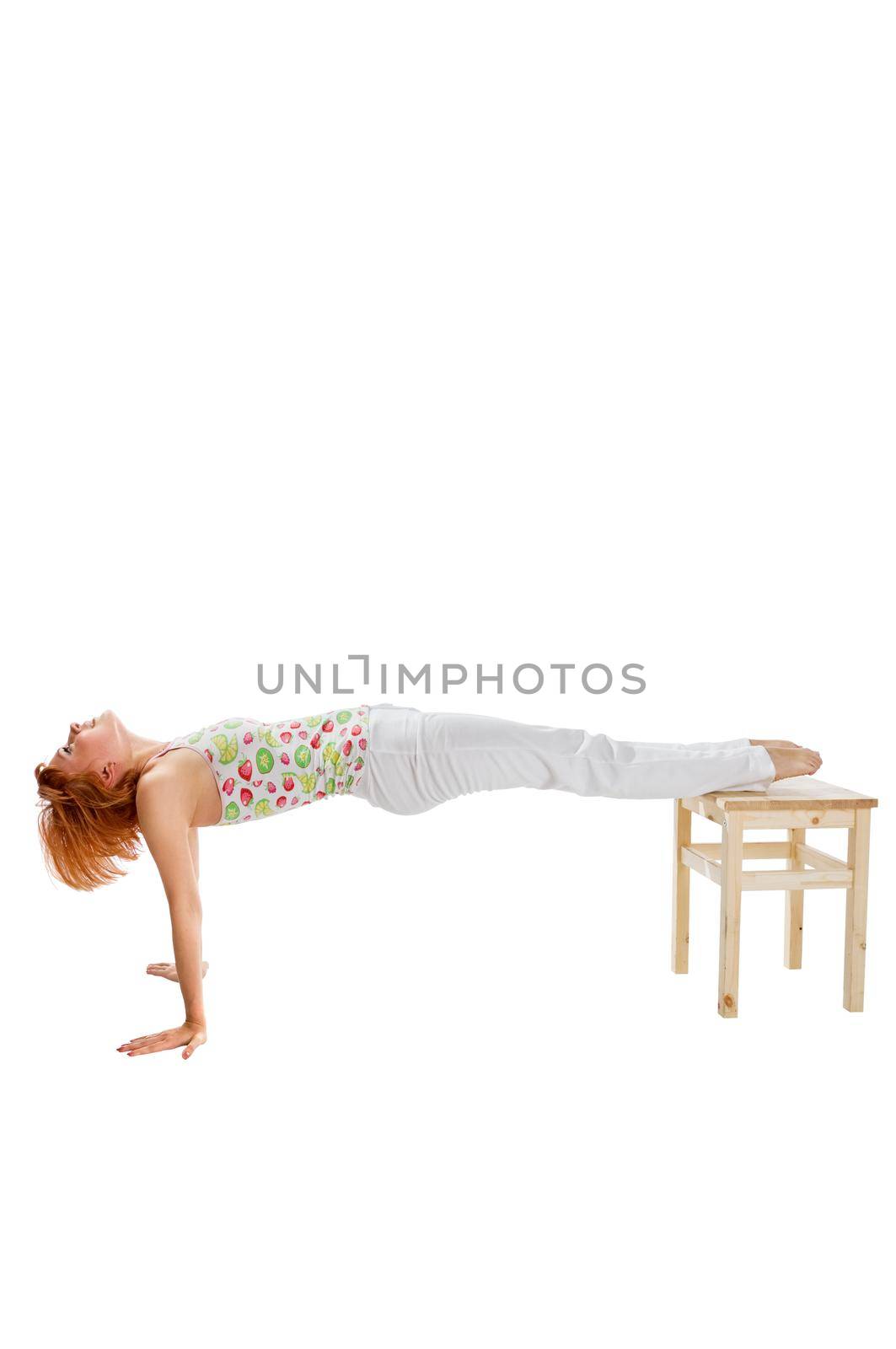 Red haired girl performing fitness exercises on white background